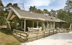 Vester SømarkenにあるNice Home In Nex With 4 Bedrooms, Sauna And Wifiのデッキ、テーブル、椅子付