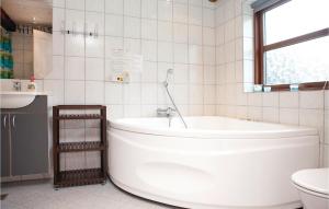 un bagno bianco con vasca e WC di Three-Bedroom Holiday Home In Hjorring a Lønstrup