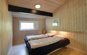 Vester SømarkenにあるNice Home In Nex With 4 Bedrooms, Sauna And Wifiの木製の壁のベッドルーム1室(ベッド1台付)