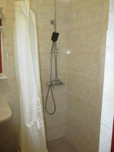 a shower with a shower curtain in a bathroom at Italian Courtyard in Feodosiya