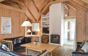 sala de estar con mesa y chimenea en Lovely Home In Hvide Sande With Kitchen, en Havrvig
