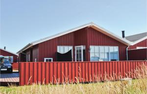 a red house with a red fence in front of it at Stunning Home In Hvide Sande With 3 Bedrooms And Wifi in Nørre Lyngvig