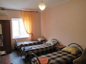 a room with two beds and a window at Italian Courtyard in Feodosiya