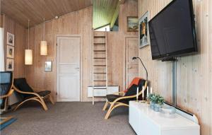 sala de estar con 2 sillas y TV en la pared en 4 Bedroom Beautiful Home In Lkken en Løkken