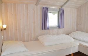 Kirke-HyllingeにあるNice Home In Kirke Hyllinge With Wifiの窓と紫色のカーテンが備わる客室のベッド2台