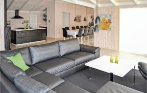 salon ze skórzaną kanapą i kuchnią w obiekcie Amazing Home In Sby With Indoor Swimming Pool w mieście Nordost