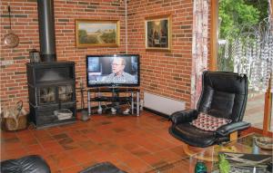 a living room with a television and a brick wall at Beautiful Home In Spttrup With Wifi in Lihme
