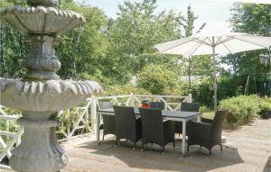 a table with chairs and an umbrella next to a fountain at Beautiful Home In Spttrup With Wifi in Lihme