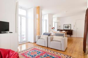 リスボンにあるBairrus Lisbon Apartments - Graçaのリビングルーム(白い椅子2脚、テレビ付)