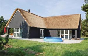 una casa con un frisbee azul delante de ella en Beautiful Home In Blvand With 5 Bedrooms, Sauna And Wifi en Blåvand