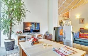 sala de estar con mesa y TV en Beautiful Home In Blvand With 5 Bedrooms, Sauna And Wifi en Blåvand