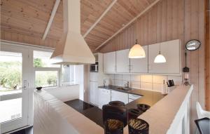 a kitchen with white cabinets and a large counter top at Awesome Home In Juelsminde With Kitchen in Sønderby