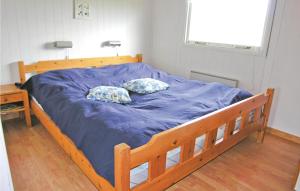 un letto con lenzuola blu e due cuscini sopra di Holiday Home Svenstibakkevej Frøstrup Xii a Lild Strand Altre 3 foto