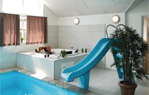 a man and a woman in a bathroom with a slide at Nice Home In Tranekr With Sauna, Wifi And Indoor Swimming Pool in Hou