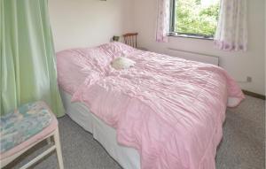 ein Schlafzimmer mit einem rosa Bett mit einem ausgestopften Tier darauf in der Unterkunft 3 Bedroom Stunning Home In Fars in Ertebølle
