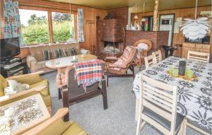 een woonkamer met een tafel en stoelen en een open haard bij 3 Bedroom Stunning Home In Fars in Ertebølle