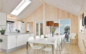 a kitchen and dining room with a white table and chairs at Nice Home In Tranekr With Sauna, Wifi And Indoor Swimming Pool in Hou