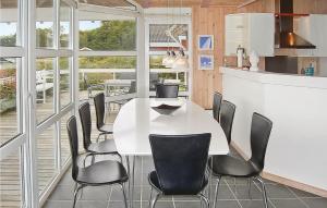 a dining room with a white table and black chairs at Holiday Home Hvedemarken Vi in Hejls