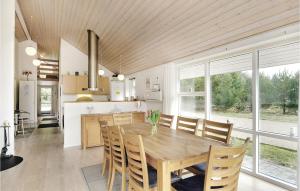 cocina y comedor con mesa de madera y sillas en 7 Bedroom Stunning Home In Herning, en Kølkær