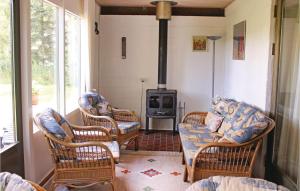 sala de estar con sillas de mimbre y estufa de leña en 3 Bedroom Stunning Home In Nykbing M, en Hesselbjerg