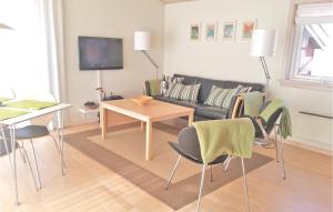 R Golfferiehuse في غودهيم: غرفة معيشة مع أريكة وطاولة وكراسي