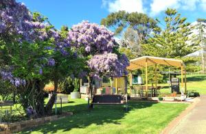 una caravana en un parque con un árbol con flores púrpuras en Amble'a'While on Tamar, en Rosevears