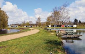 a park with benches next to a river with houses at Holiday Home Dyrefolden Ringkøbing Ii in Ringkøbing