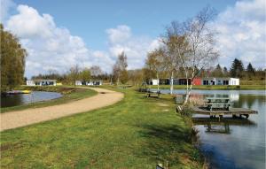 a park with benches next to a river with houses at Holiday Home Dyrefolden Ringkøbing Vi in Hee