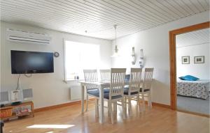 FrøstrupにあるAmazing Home In Frstrup With 4 Bedrooms And Wifiのダイニングルーム(テーブル、椅子、テレビ付)
