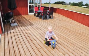 a young boy sitting on a deck playing with a toy car at Holiday Home Havmose Iii in Asserballeskov +13 photos