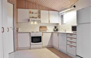 una cucina con mobili bianchi e un forno a piano cottura di Holiday Home Wolle Friks Vej Ringkøbing Denm a Søndervig Altre 12 foto