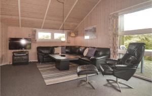 - un salon avec un canapé en cuir, une table et des chaises dans l'établissement Amazing Home In Blvand With Kitchen, à Blåvand