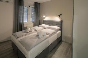 1 dormitorio con 1 cama grande con sábanas y almohadas blancas en Live & Sleep en Novi Sad