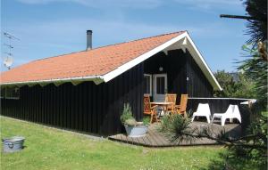 a black house with a deck with chairs and a table at Nice Home In Humble With 4 Bedrooms, Sauna And Wifi in Humble