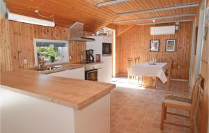 a kitchen with a counter and a table in a room at Holiday Home Vestermarken Blåvand Iv in Blåvand +21 photos