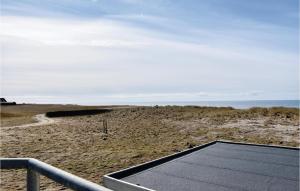 a tennis court on a beach with the ocean in the background at Two-Bedroom Holiday Home In Lemvig in Nørby
