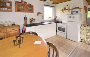 uma cozinha com uma mesa de madeira e um frigorífico branco em 2 Bedroom Stunning Home In Fars em Hvalpsund