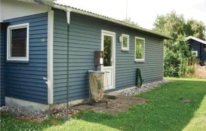 una casa azul con un cubo de basura fuera de ella en 2 Bedroom Stunning Home In Fars en Hvalpsund
