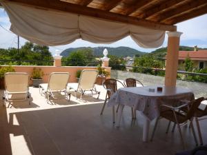 a table and chairs on a patio with a view at Kostas Apartments & studios in Agios Georgios Pagon