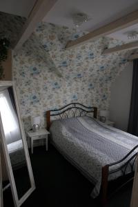 a bedroom with a bed with a floral wallpaper at DP Art Residence - self check in in Kaunas