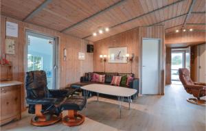 a living room with a table and chairs and a couch at Gorgeous Home In Ringkøbing With Sauna in Klegod +14 photos