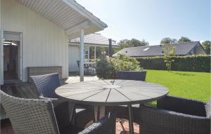 a table with chairs and an umbrella on a patio at Holiday Home Hoelgårdvej in Kelstrup