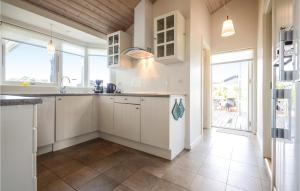 a kitchen with white cabinets and a large window at Holiday Home Hoelgårdvej in Kelstrup