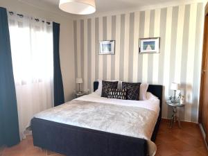 a bedroom with a bed and a striped wall at Duplexe Marina Beach in Restinga Smir