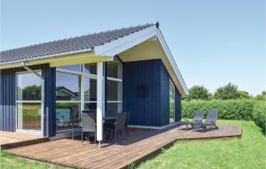 una terrazza in legno con sedie e una casa di Nice Home In Rudkbing With Kitchen a Spodsbjerg