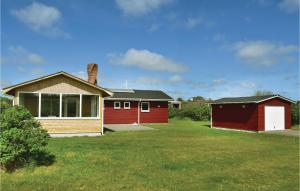 スナーヴィグにあるLovely Home In Ringkbing With Saunaの庭赤い家屋と赤いガレージ