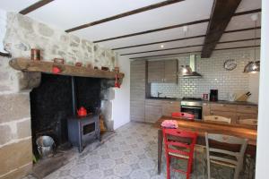 een keuken met een open haard en een tafel en stoelen bij Lava Lodge in Espinasse
