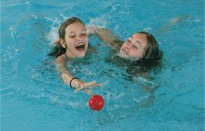 two girls playing with a ball in a swimming pool at Skærbæk Fritidscenter in Skærbæk