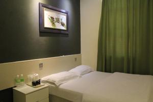 1 dormitorio con cama blanca y cortina verde en Putra One Avenue Hotel, en Seri Kembangan