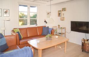 een woonkamer met een bank en een salontafel bij Pet Friendly Home In Oksbl With Sauna in Vejers Strand